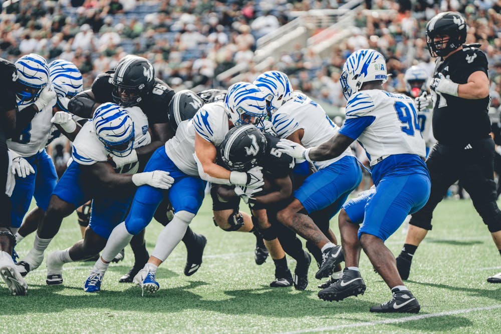 The Memphis defense swarms around a South Florida runner.