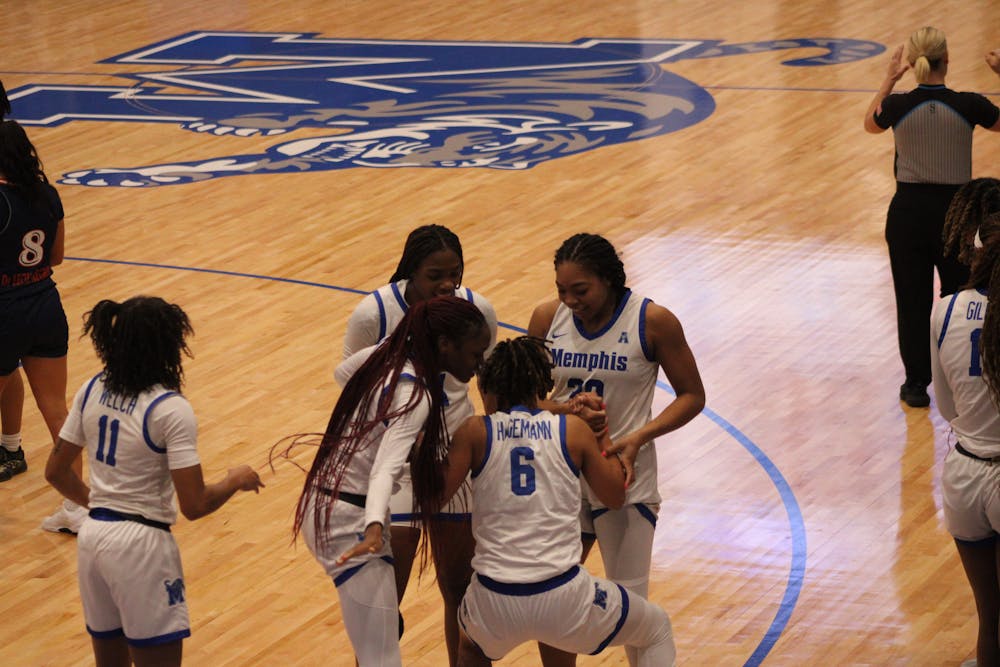 DeeDee Hagemann is helped up by her teammates after hitting a corner three.