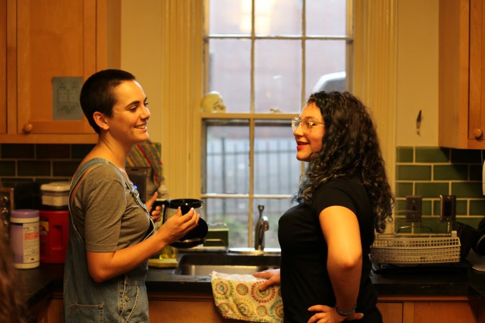 Meg Pendoley, evening program assistant, and Lily Applebaum, assistant to the faculty director, share a laugh at the kitchen in Kelly Writers House.&nbsp;