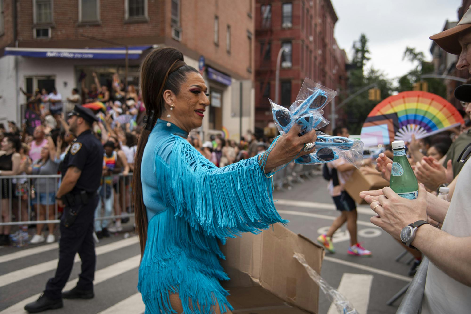 A drag queen hands out sunglasses at Pride