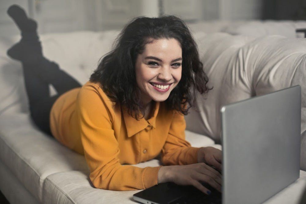 negative-space-woman-couch-laptop-computer-happy-smile-bruce-mars-thumb-1
