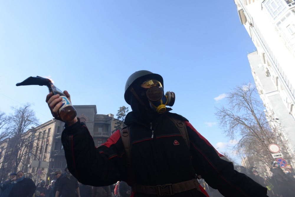 masked_protester_holding_molotov_cocktails_seen_du