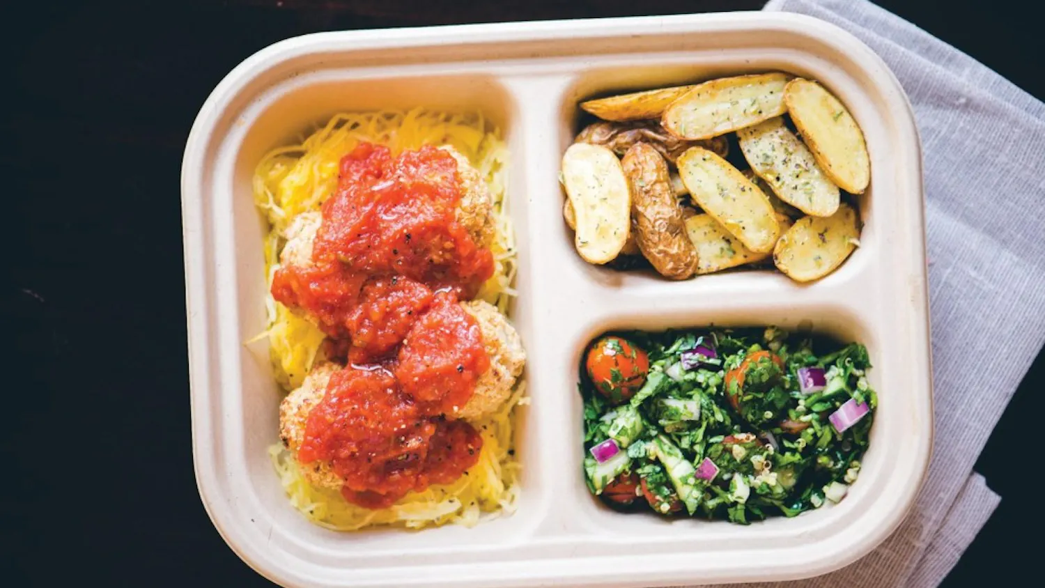 An Herban Quality Eats plate made of seasoned spaghetti squash, vegan Jawn (made of white beans, lentils, sweet potato and quinoa), herbed tomato sauce, crispy rosemary potatoes and quinoa tabouli salad. | Courtesy of Amir Fardshisheh/Herban Quality Eats