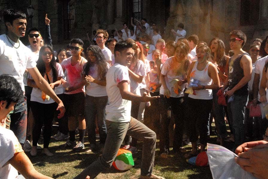 People throw color powders at each other.