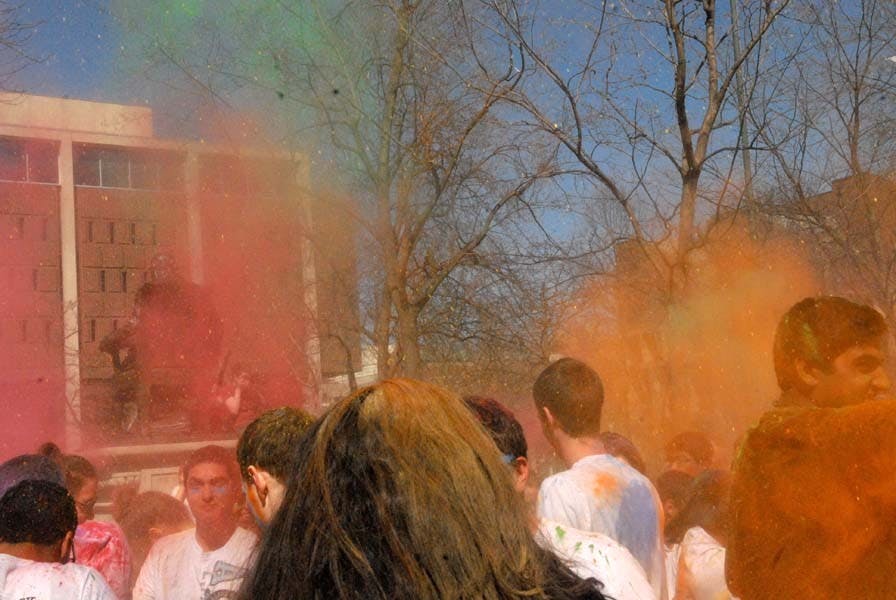 People throw color powders at each other.