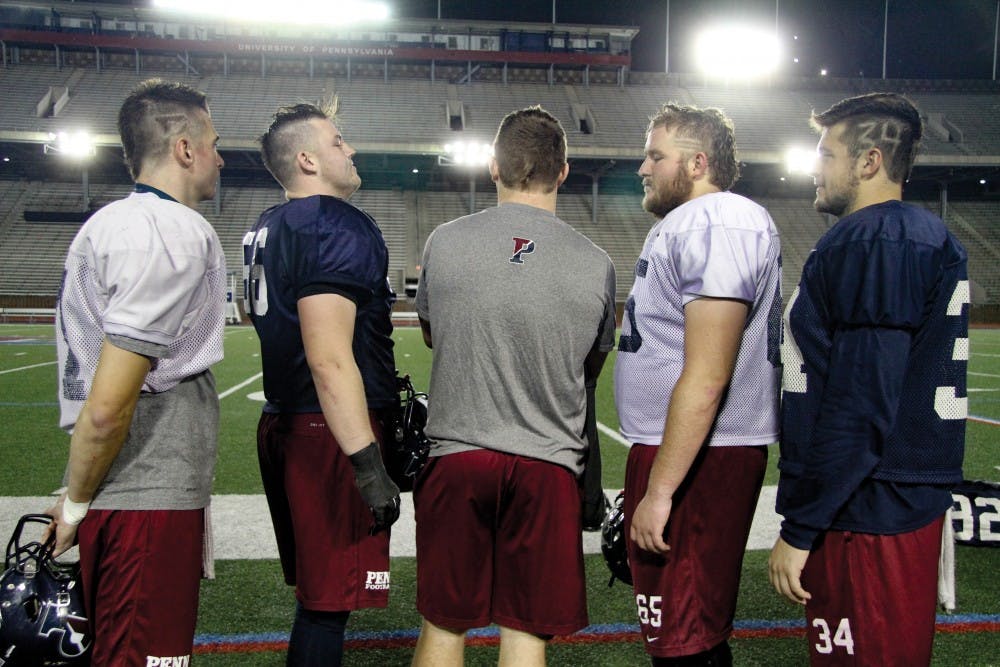 Members of Penn football, including senior linebacker Nolan Biegel (center),senior center Jack York (middle-right) and junior linebacker Donald Panciello (far right) have altered their hairstyles in unique ways for the Ivy League stretch run. Panciello even included his uniform number in his cut.