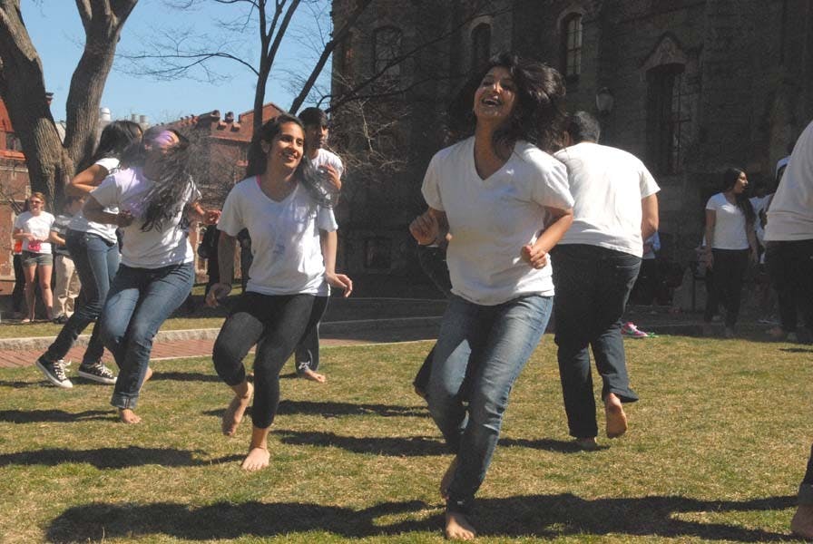 People throw color powders at each other.