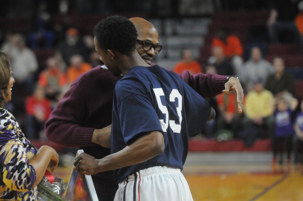 Head coach Jerome Allen greets Cameron Crocker at mid-court before Tuesday's Ivy League matchup with Princeton during senior night festivities. By Thomas Munson