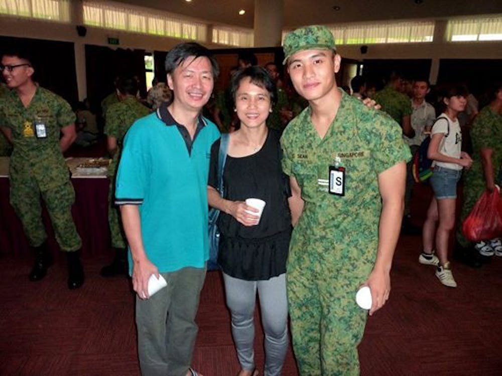 Ying Cong Seah with his parents in Singapore Armed Forces uniform.