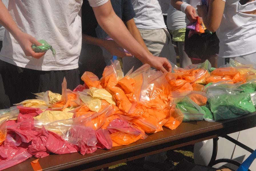 People throw color powders at each other.