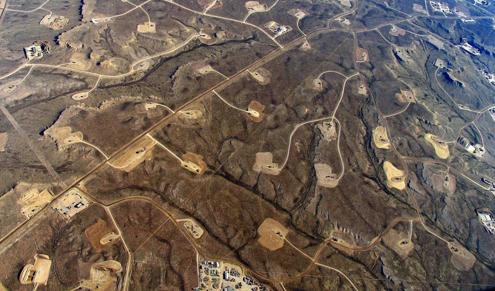 Areas with heavy fracking activity are marked by patterns of pipelines, roads, and well pads.