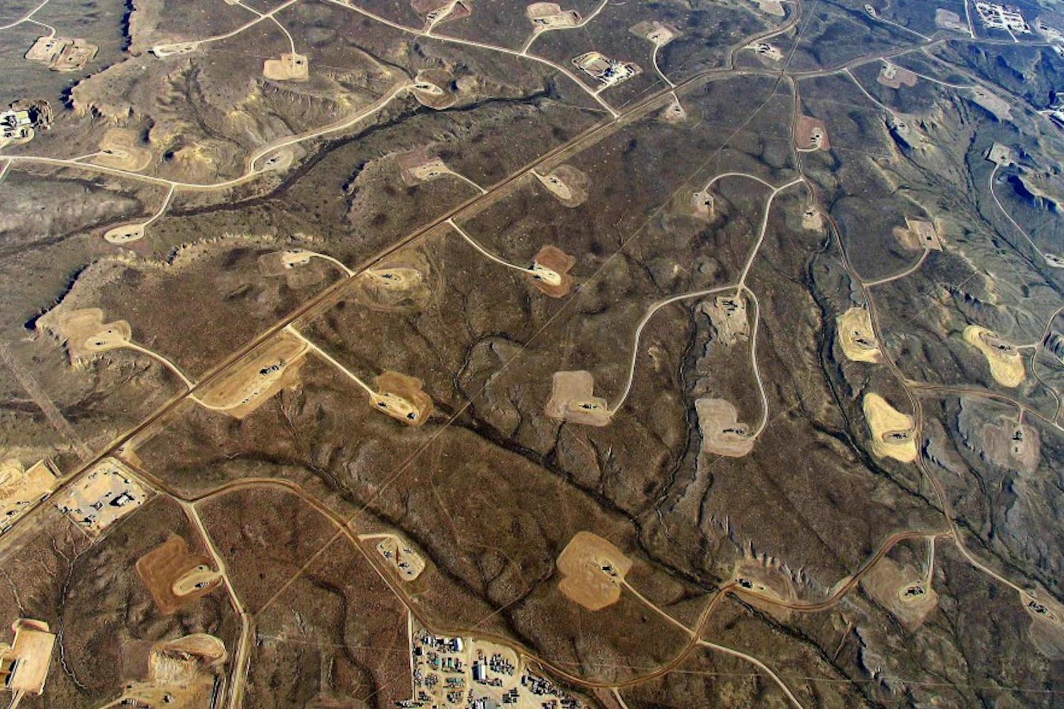 Areas with heavy fracking activity are marked by patterns of pipelines, roads, and well pads.