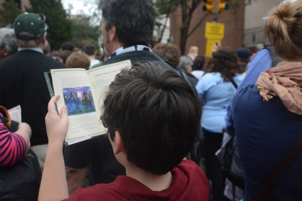 A young boy passed the time in line by reading a Star Wars book.