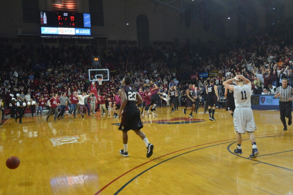 The thrill of victory and agony of defeat: Harvard senior forward Wesley Saunders (#23) walks towards a crowd of adoring fans while Yale freshman guard Makai Mason (#11) walks off in defeat.