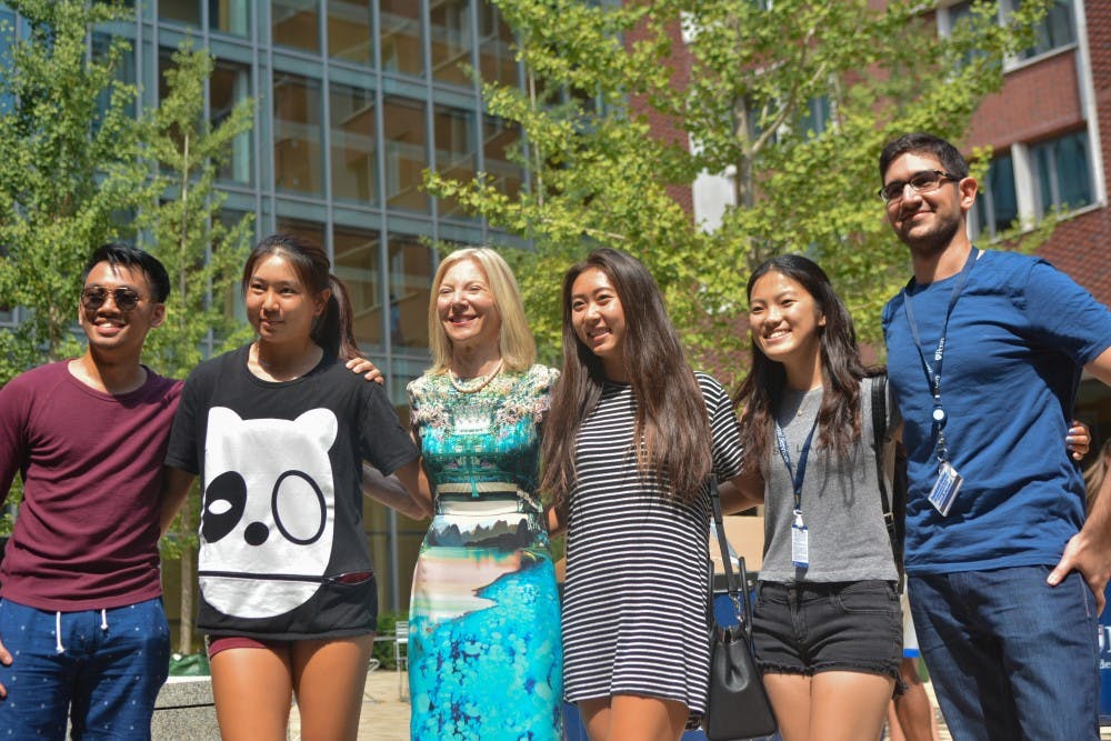 President Gutmann posed with students in New College House's airy courtyard.