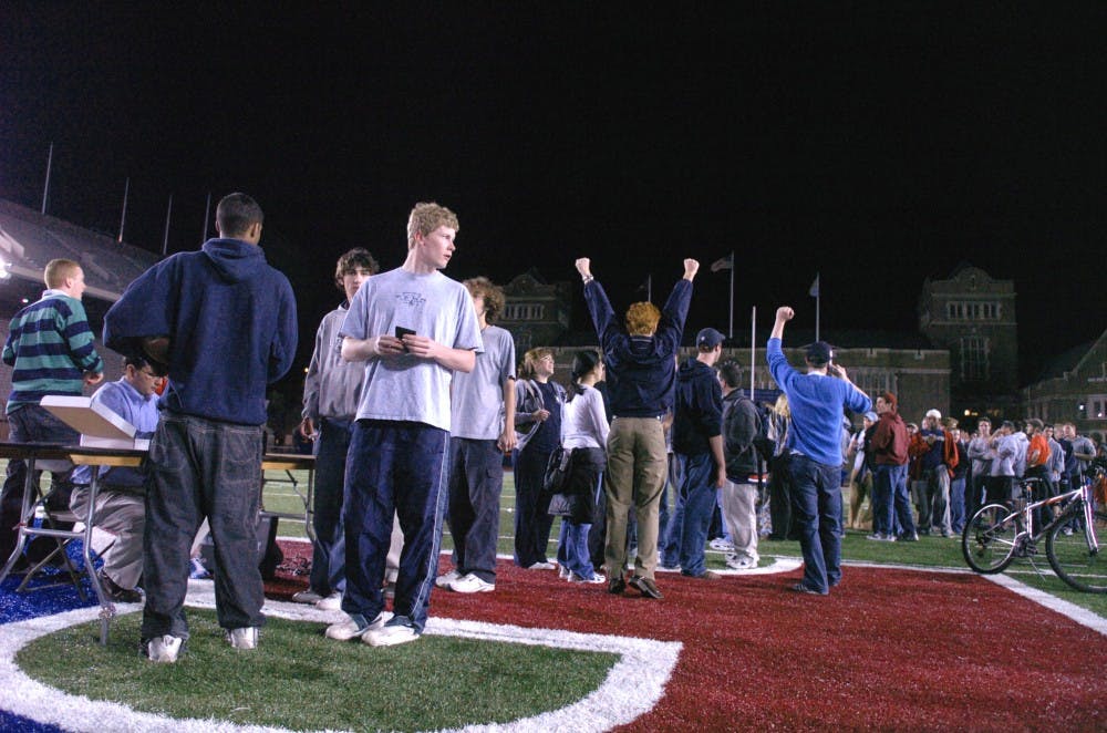 DP Sports editor Jeff Schaefer cheers as scores are announced over the radio.the line, at franklin field