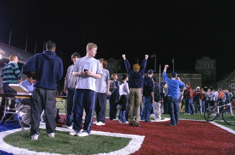 DP Sports editor Jeff Schaefer cheers as scores are announced over the radio.
the line, at franklin field