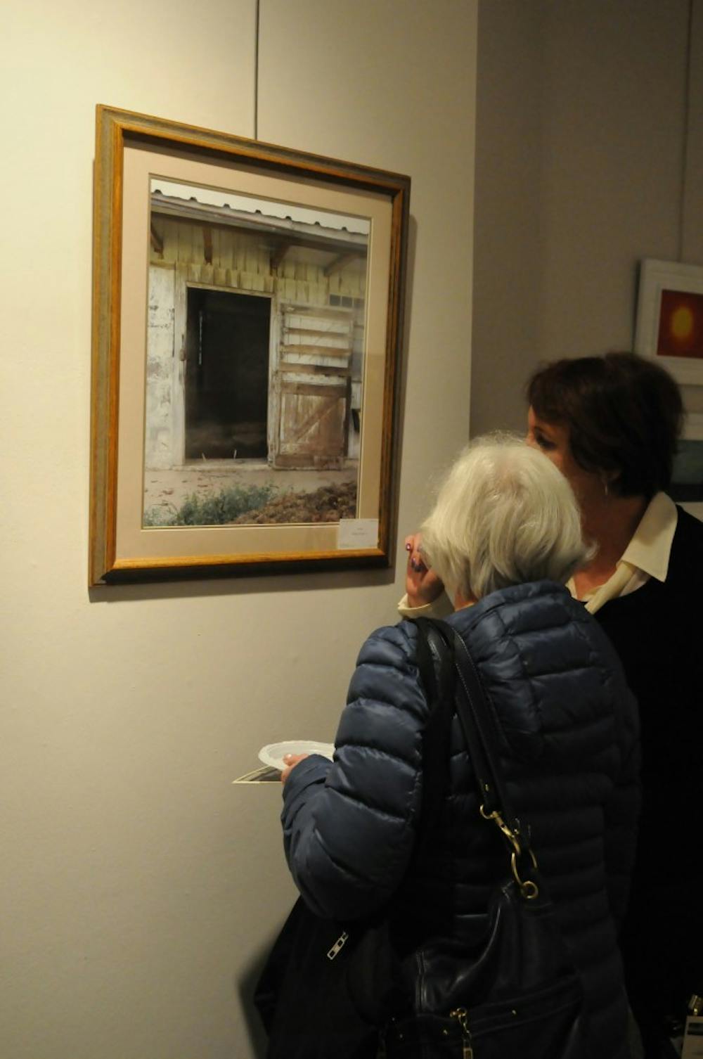 	Visitors to the “Journey to Recovery” art gallery in examine a piece of art. The gallery displayed artwork created by people who suffer from mental illness.