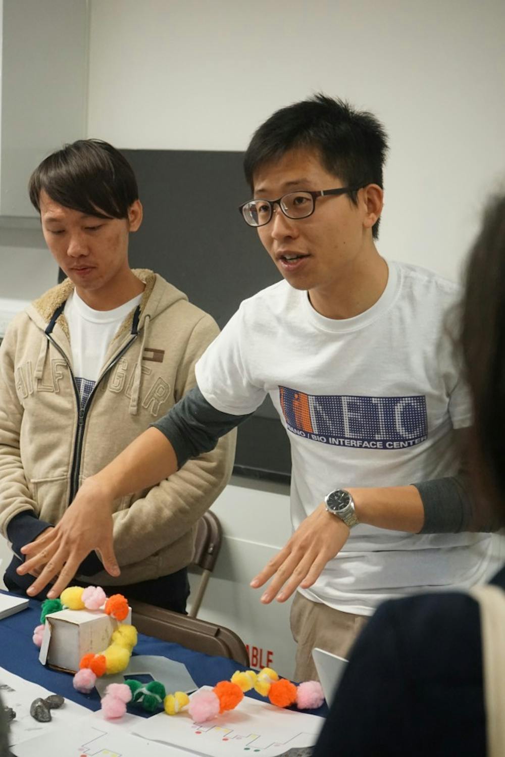 Penn researcher Francis Chen (right) demostrated the properties of a graphene to high school students in Singh Center during the NanoDays festival last week.