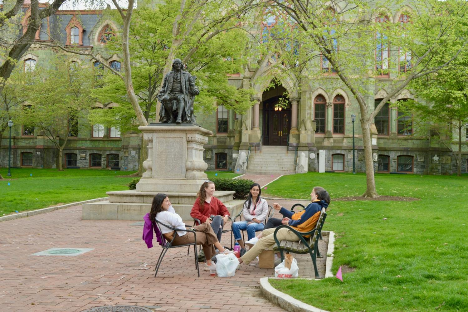04-18-21 College Green Benjamin Franklin Statue Friends Sitting Acme Smiling College Hall (Maya Pratt).jpg