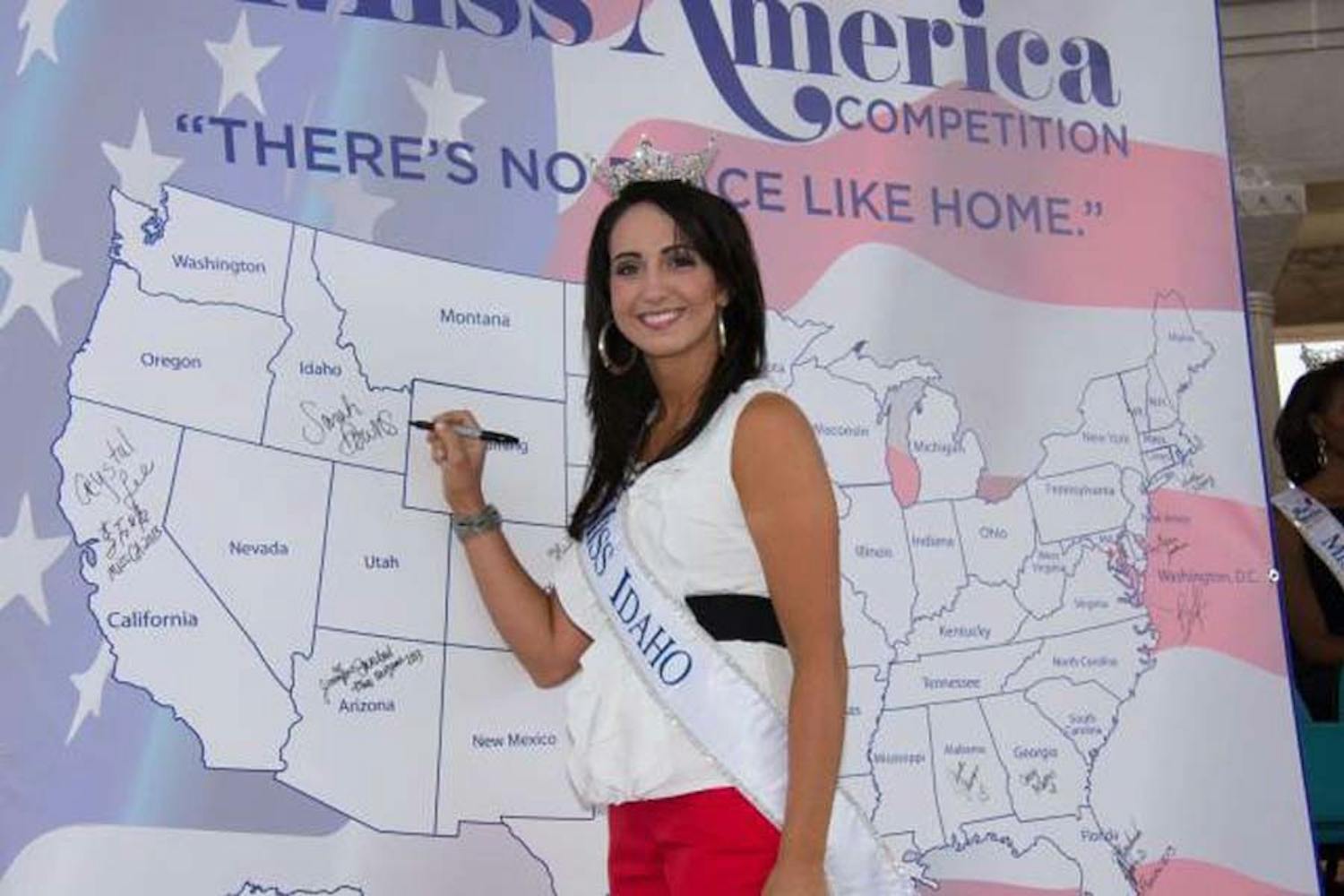 Sarah Downs, this year’s Miss Idaho and a 2012 College graduate, signs her name on her home state at the Miss America competition. She did not make the top 15.