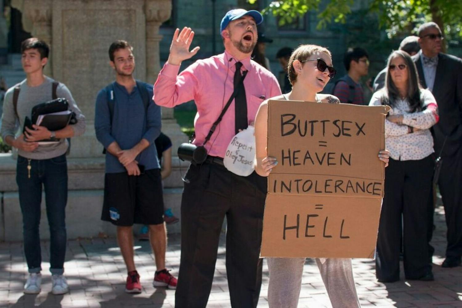 Next to one of the preachers, College senior Rebecca van Sciver held a sign reading, "Buttsex = Heaven" and "Intolerance = Hell." 
