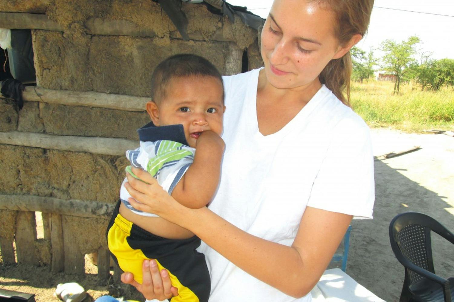 2012 College graduate Monika Wasik, the field coordinator for the Chaco Area Reproductive Ecology Program, works with a young child in Argentina.