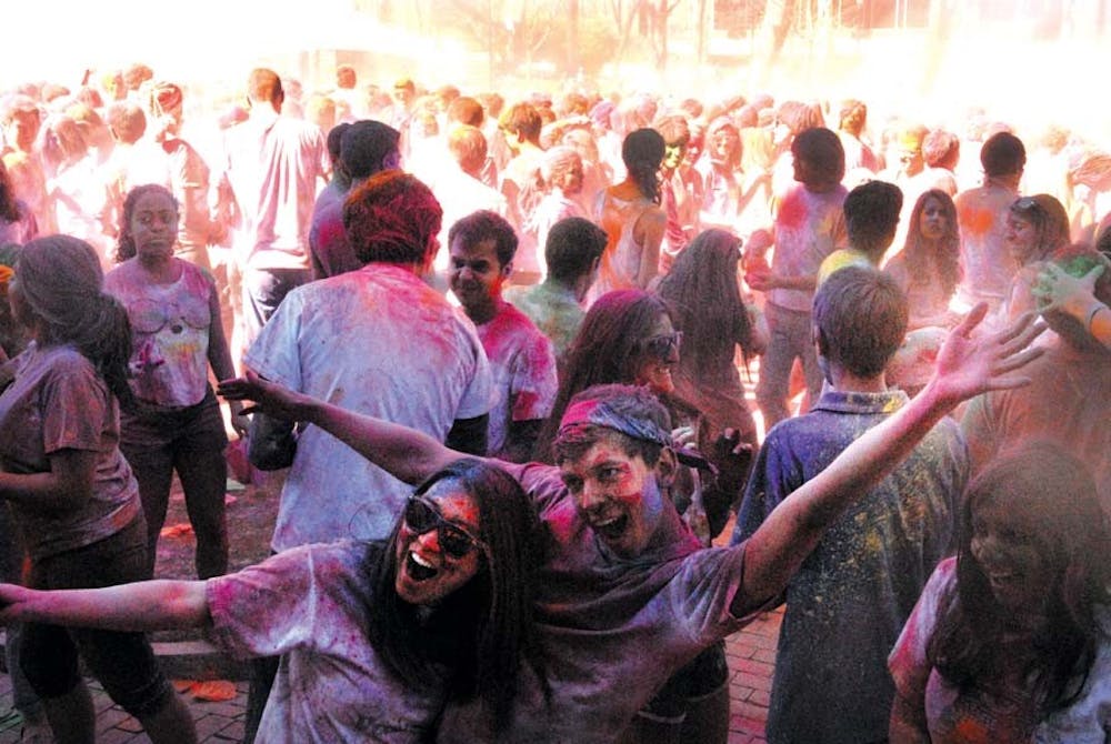 People throw color powders at each other.
