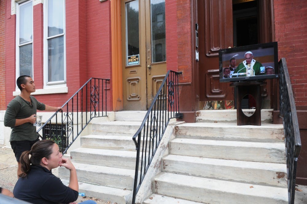Those stuck in line watched Philadelphians' makeshift displays of Sunday's papal mass.