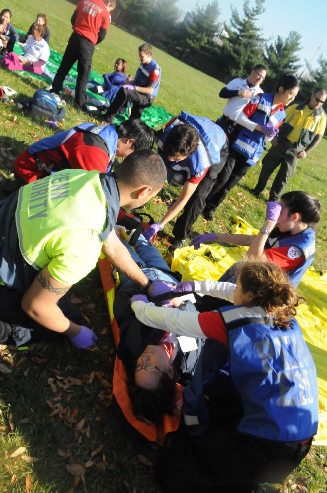 	MERT members respond to simulated mass casualty incident of a car and bus collision. The injured wore makeup and fake lacerations to make the simulation more realistic.