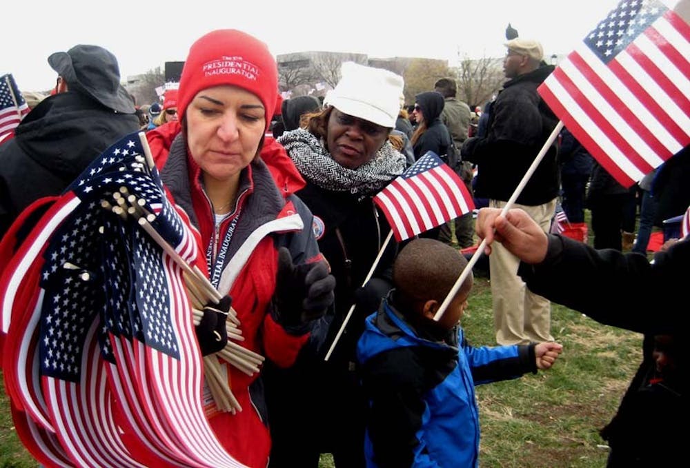	A volunteer hands out American flags to attendees on the National Mall.