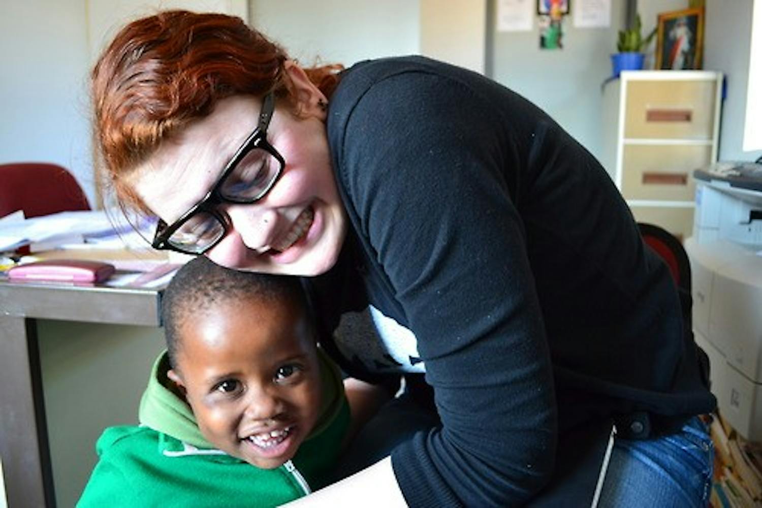 Rising College junior Rosa Escandon hugs a student at Kamogelo Orphanage in Botswana. Escandon and another IIP intern are trying to raise $25,000 for Kamogelo by the end of August.