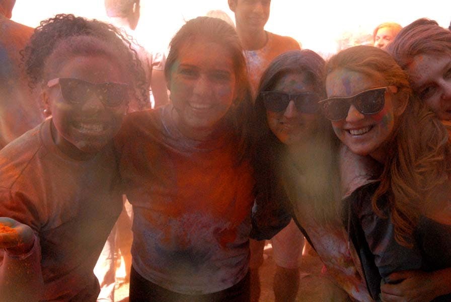 People throw color powders at each other.