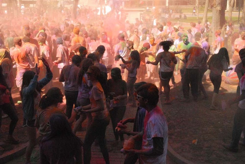 People throw color powders at each other.