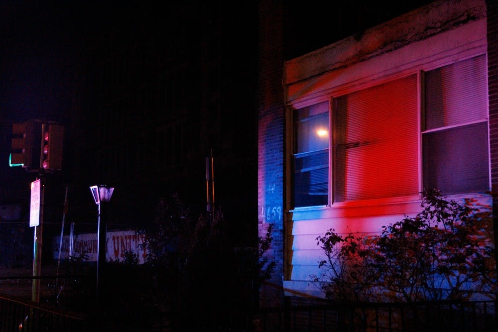 Flashing police lights painted nearby houses blue and red.