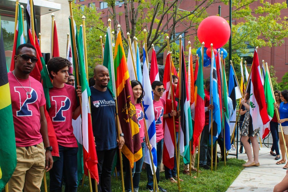 Students representing countries from around the world filed in, carrying their country's flag.
