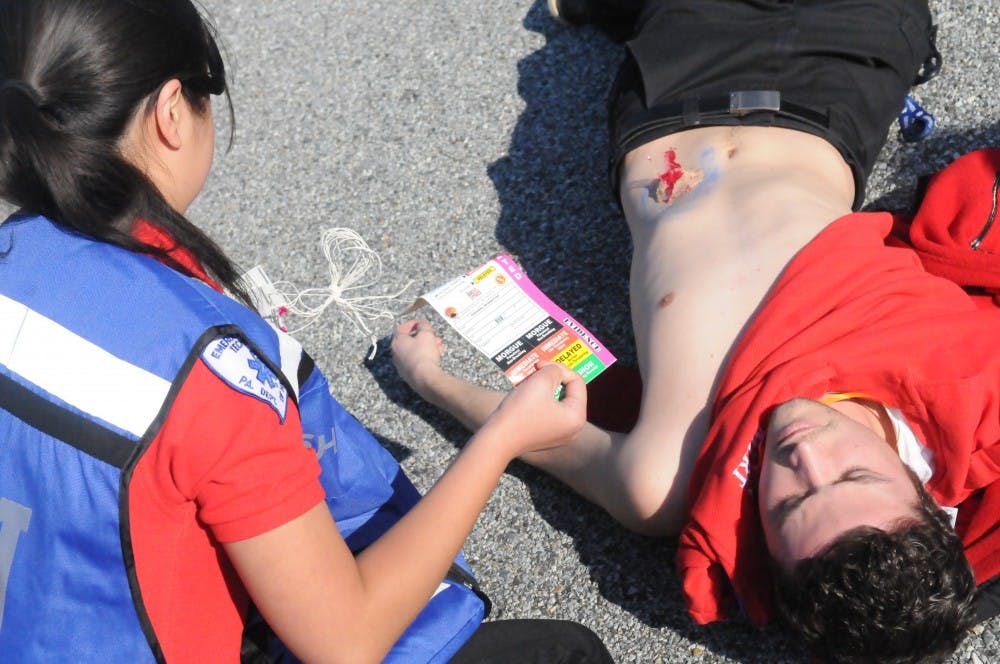 	MERT members respond to simulated mass casualty incident of a car and bus collision. The injured wore makeup and fake lacerations to make the simulation more realistic.