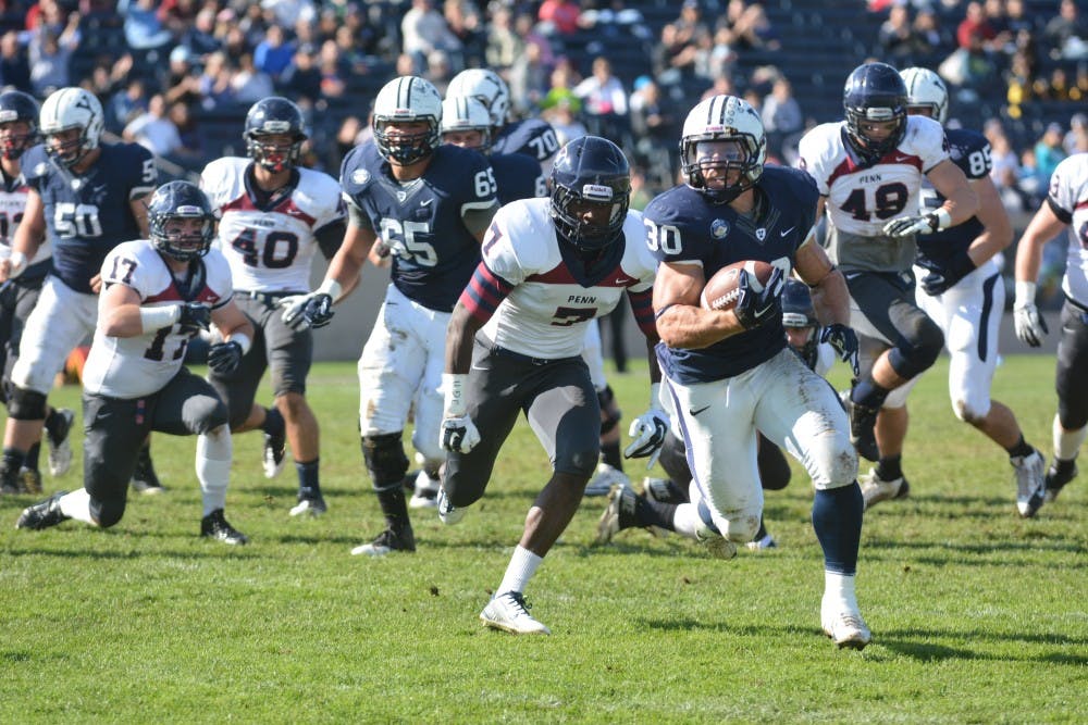 Yale senior running back Tyler Varga runs away from Penn safety Evan Jackson en route to a 23-yard touchdown run in the first quarter.