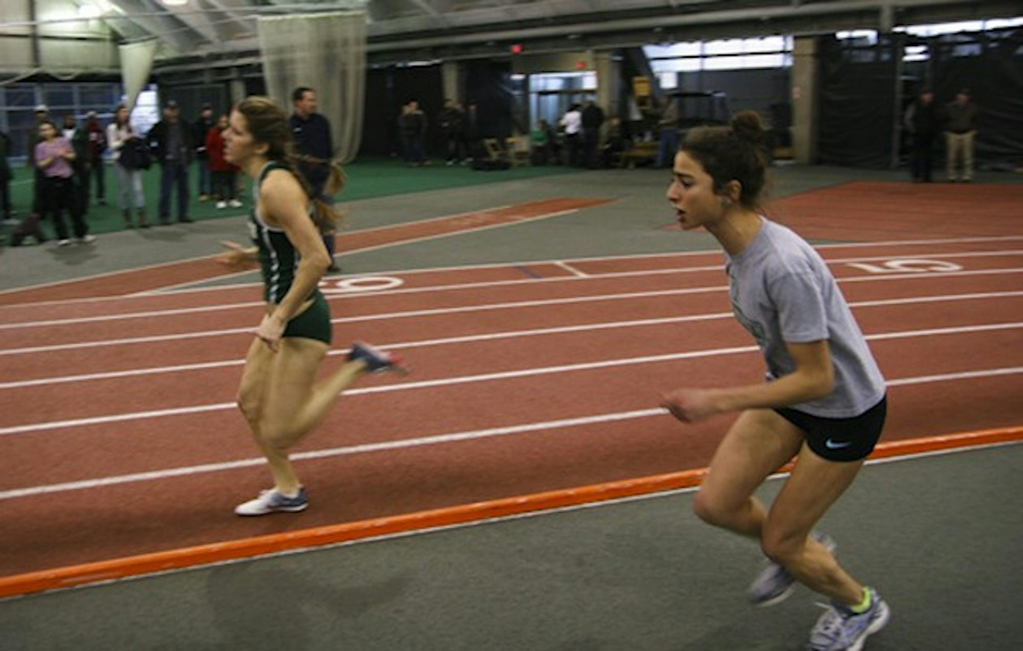 Alexi Pappas '12 (right) cheers on a teammate during the track and field team's Jan. 21 home meet against Yale and Columbia Universities.