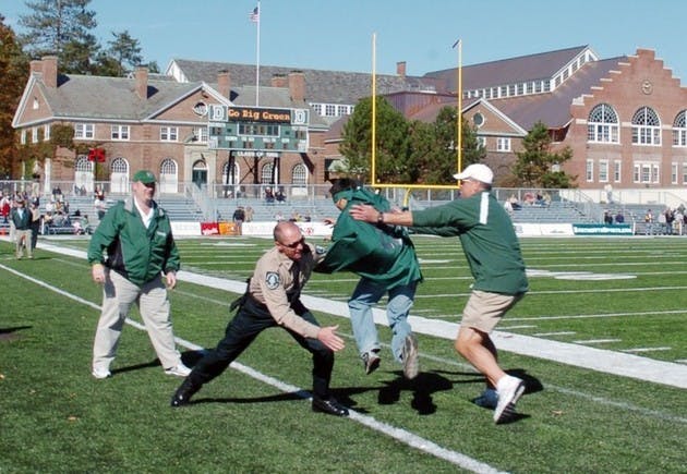 Safety and Security officers along with other football game officials tackle a freshman as he attempts to 