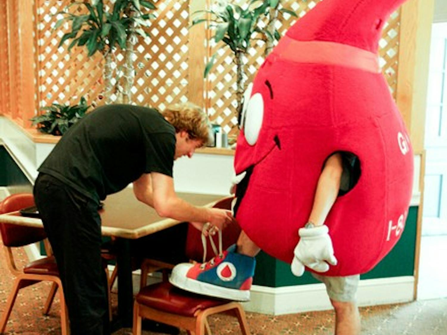 A concerned student lends a hand tying the shoe of the blood drop mascot that roams campus to advertise the blood drive Wednesday.