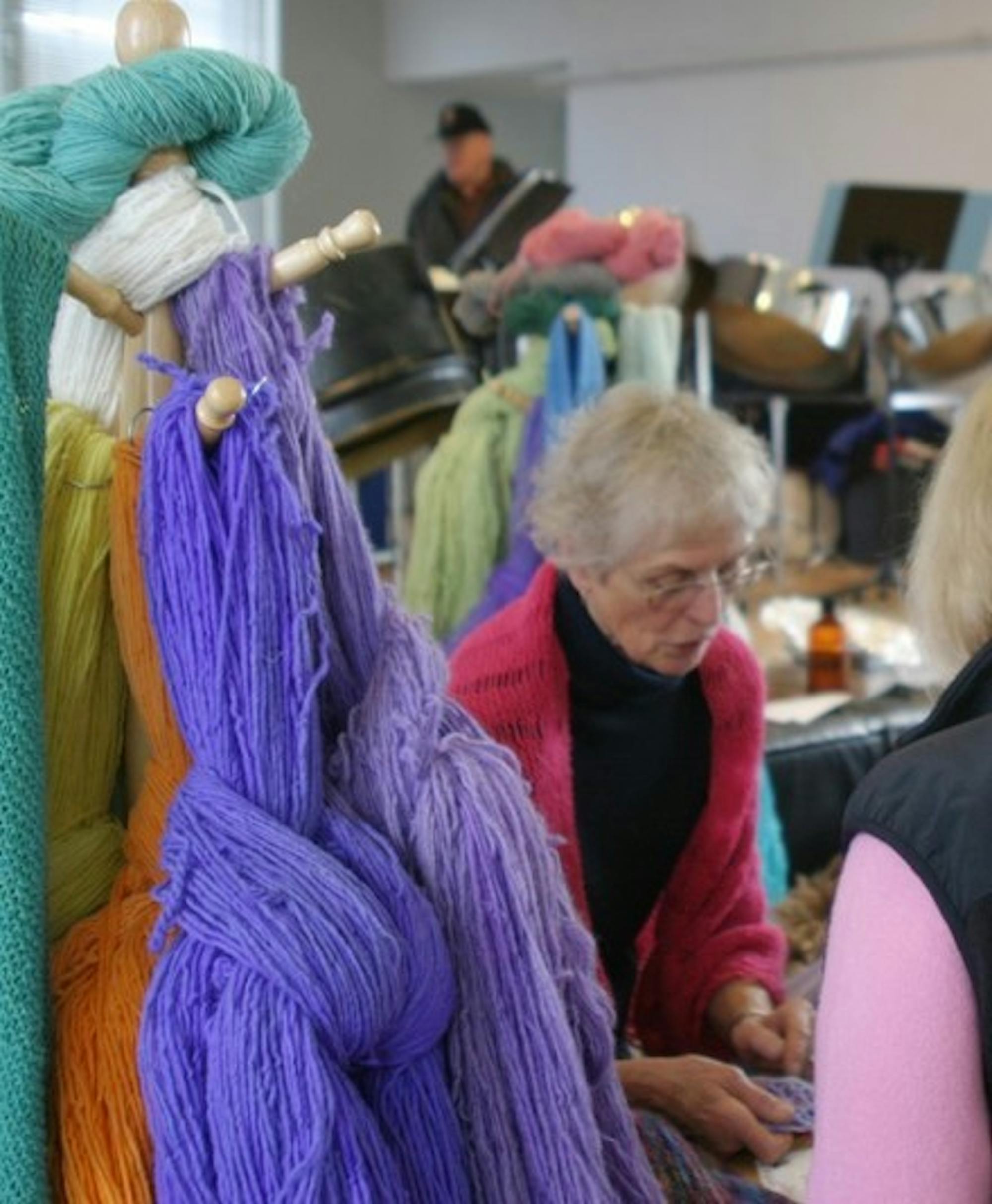 Skeins of colorful hand-spun yarn hang in the interior of Norwich's town hall Saturday while vendors exhibit their goods at the Norwich Farmers Market.