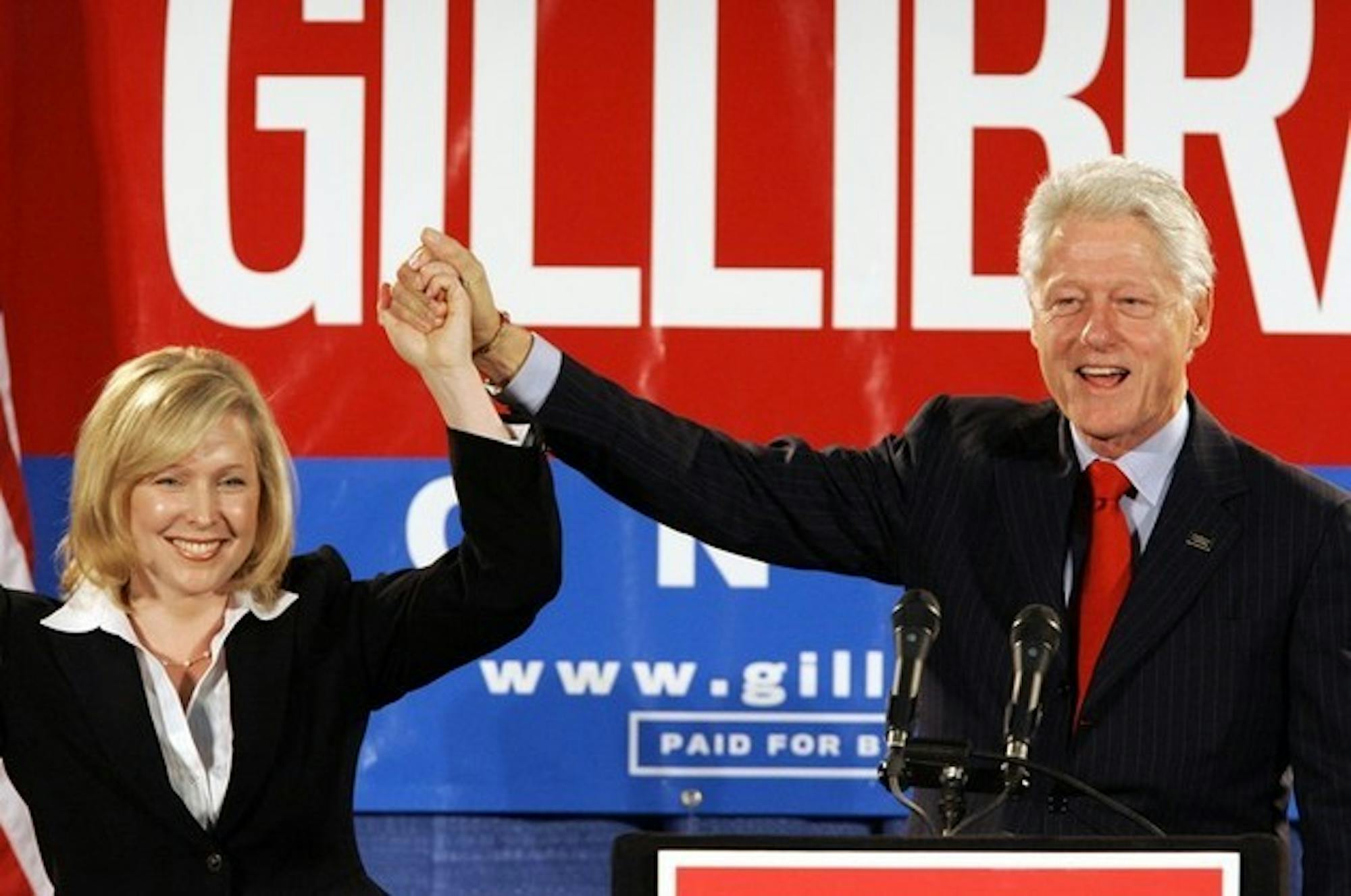 Former President Bill Clinton holds up the hand of Kirsten Gillibrand '88 at a rally on October 26th in Albany.