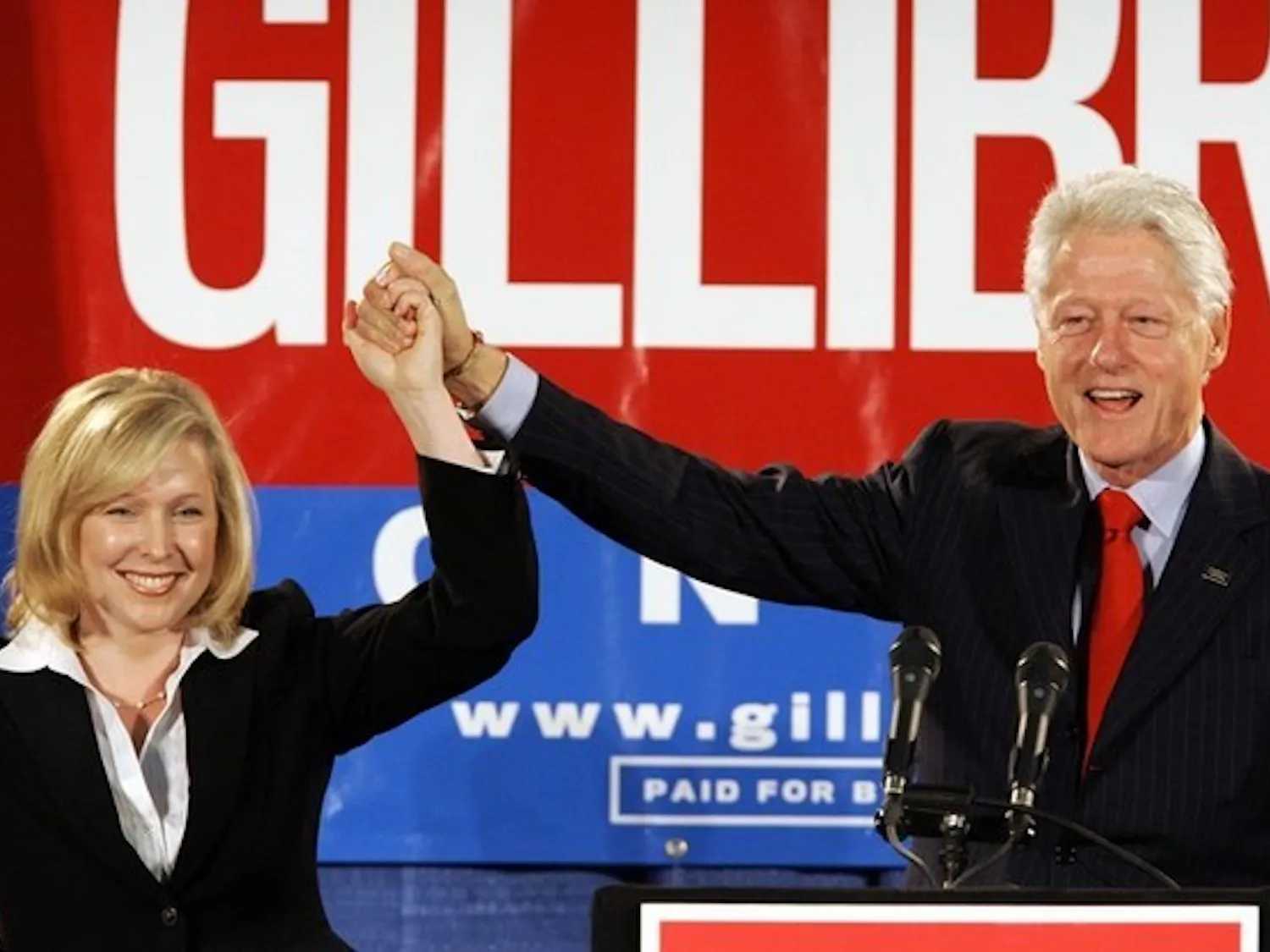 Former President Bill Clinton holds up the hand of Kirsten Gillibrand '88 at a rally on October 26th in Albany.