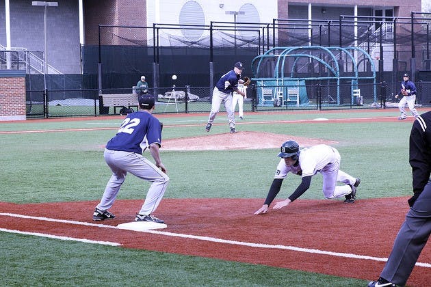 A Dartmouth runner retreats to first base during a pick-off attempt in the Big Green's 12-4 victory over St. Anselm on Wednesday.