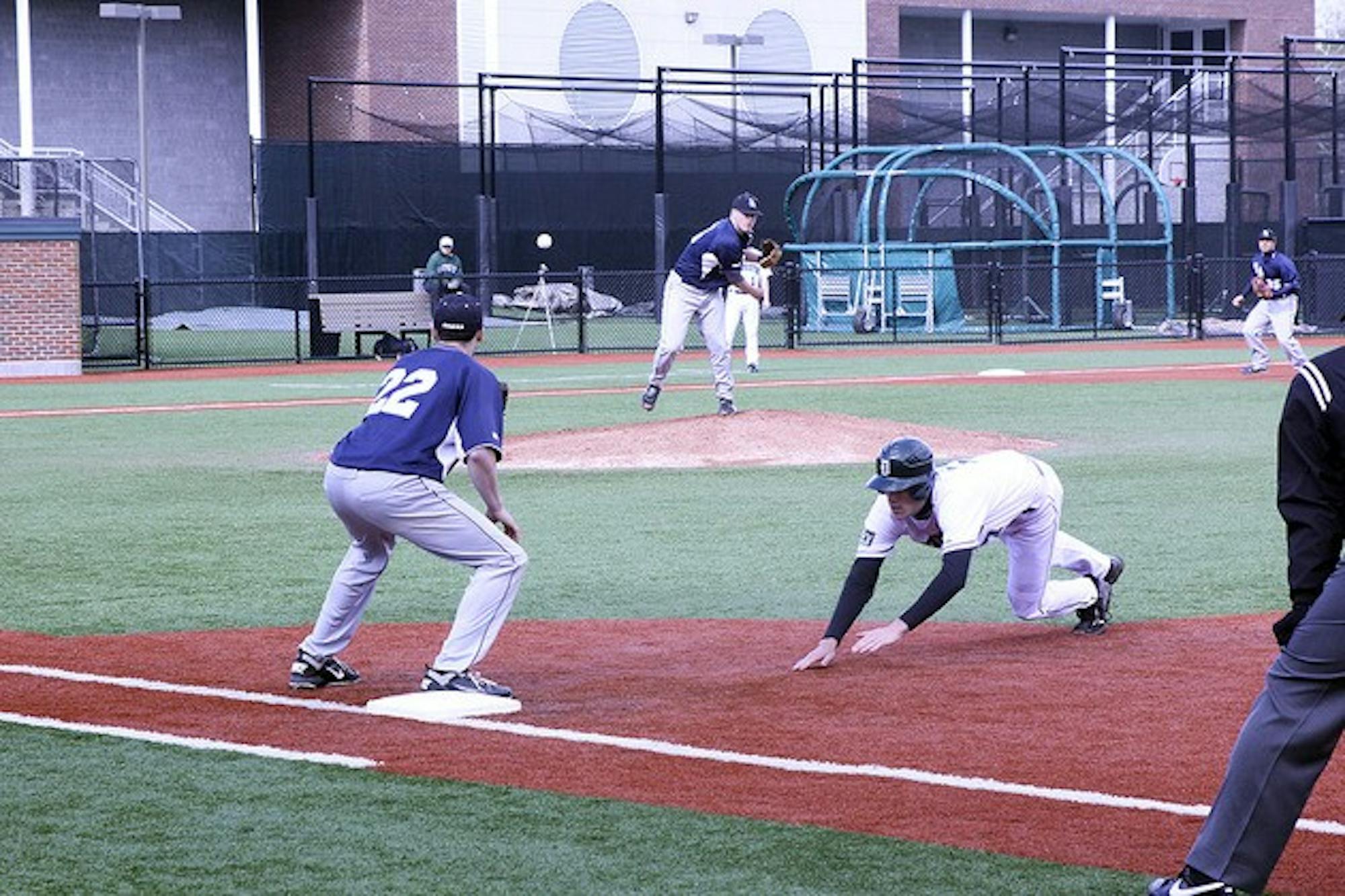 A Dartmouth runner retreats to first base during a pick-off attempt in the Big Green's 12-4 victory over St. Anselm on Wednesday.
