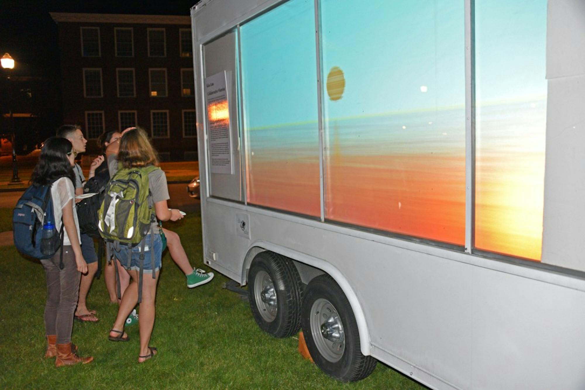 Students look at Kiko Lam’s ’14“Collaborative #Sunrise” project, featured on the Tiltfactor Lab’s “playcube.”