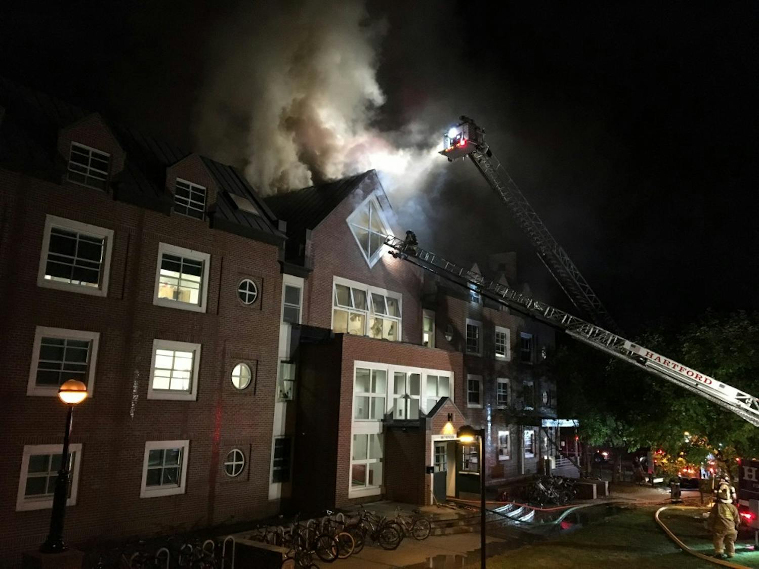 Firefighters on the ladder truck break through the window of Morton Hall as they work on a fire that broke out at around midnight on Oct 1.&nbsp;