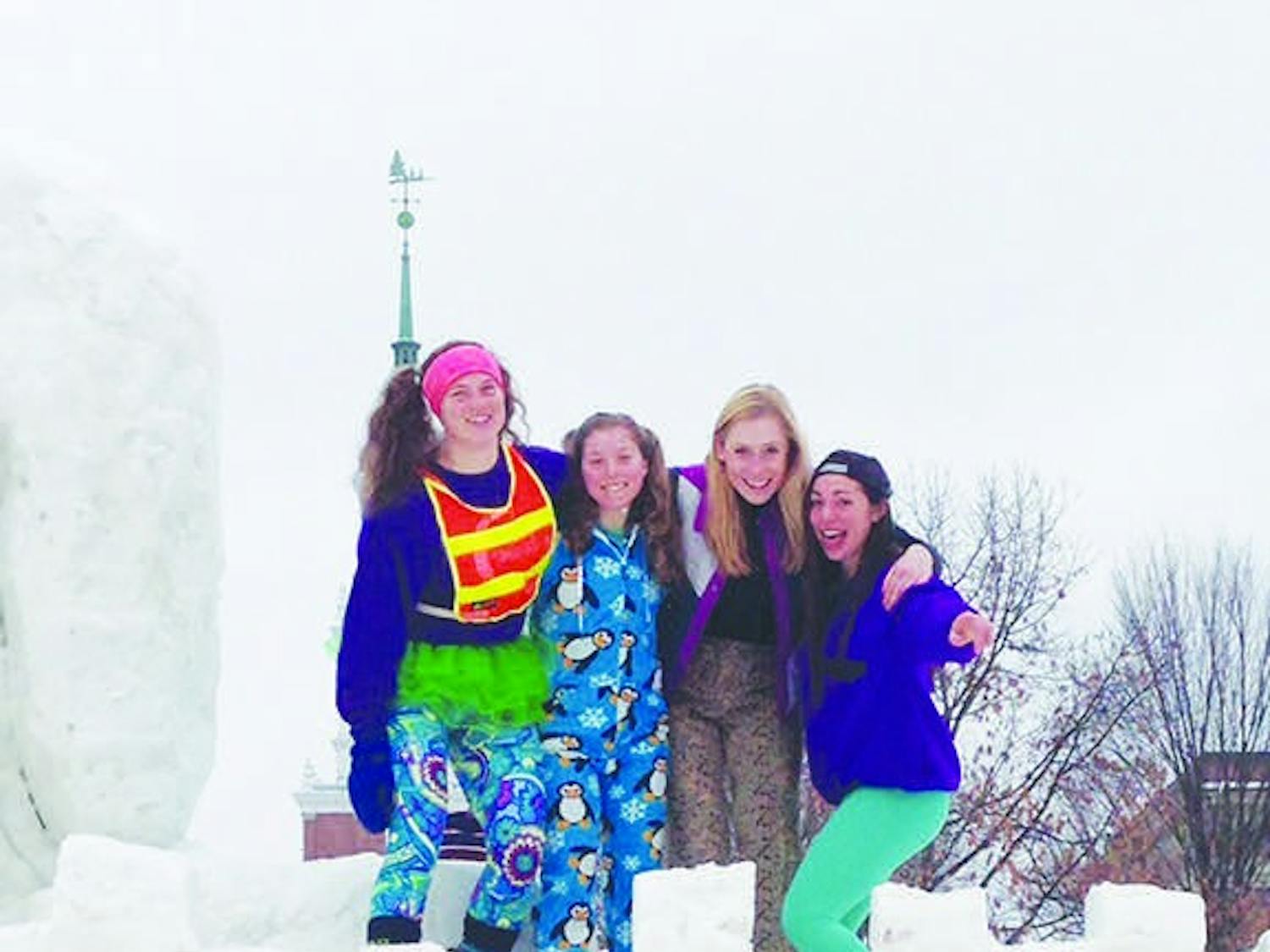 Emma Sklarin '18 (right) stands on a Winter Carnival snow sculpture with friends.&nbsp;