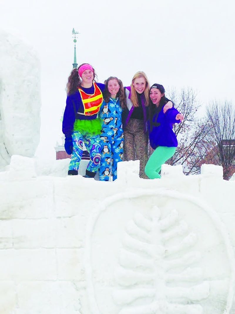 Emma Sklarin '18 (right) stands on a Winter Carnival snow sculpture with friends.&nbsp;